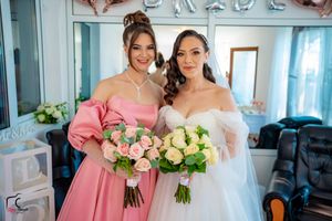Elegant wedding party members display floral bouquets in pink and cream colors.