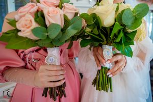 Two bouquets of pink and white roses with green foliage held side by side.