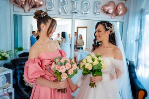 Wedding party members sharing joyful moment under balloon decorations.