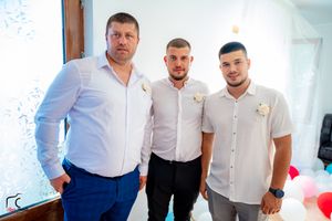 Group photo of people in white shirts and formal attire at a celebration event.