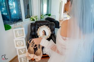 Wedding preparation scene with decorative LOVE blocks and bridal shoes near an ornate mirror.