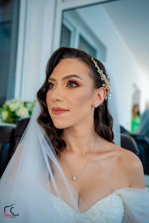 Bride in strapless wedding gown with crystal embellishments and soft romantic makeup.