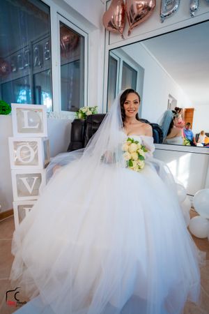 Full-length shots of bride in voluminous white ballgown with decorative LOVE letters in background.