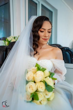 Artistic bridal portraits with soft yellow rose bouquet and flowing veil details.