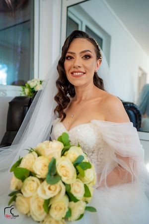 A bridal portrait series showing an elegant bouquet of cream roses and a flowing white veil in natural light.
