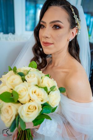 Wedding day portrait series highlighting a classic cream rose bouquet and elegant bridal styling.
