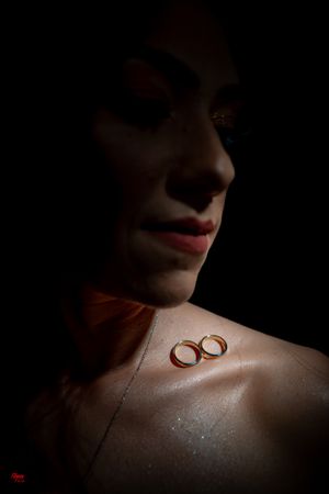 Two gold rings photographed in moody lighting with shadows and highlights.