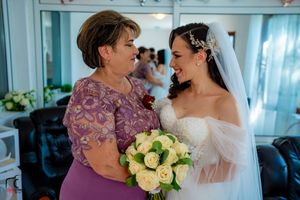 A tender moment shared between two people with white roses and wedding attire.