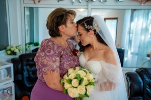 A sweet wedding moment captured as two people share an affectionate forehead touch.