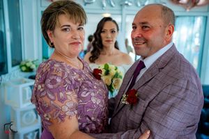 Wedding party members interact in a blue-toned room with BRIDE wall decor.