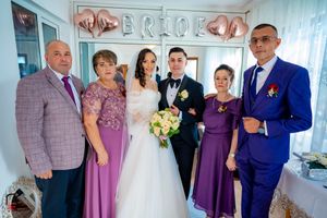 Wedding group photo featuring mix of formal attire in purple, blue and gray.