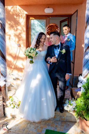 Couple shares intimate moment in doorway of Mediterranean venue.
