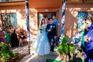 Wedding celebration on terracotta porch with guests watching from garden.