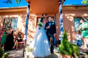 Wedding guests gathered along a peach-colored wall during an outdoor celebration.