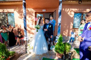 Joyful wedding celebration with guests and decorative elements against terra cotta walls.