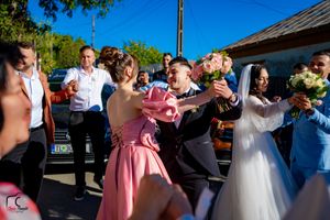 Wedding party members dancing and celebrating at an outdoor reception.