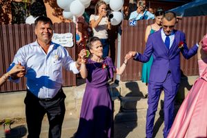 Wedding guests dance and celebrate with white balloons at an outdoor reception party.