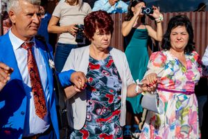 Wedding guests taking photos and celebrating at an outdoor reception on a sunny day.