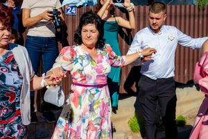 Guests capturing photos with cameras and phones at a festive outdoor gathering.