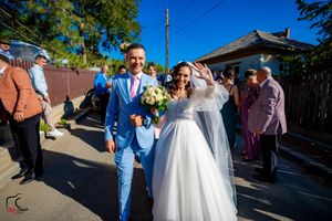 Wedding celebration on a sunny day with guests lining the street.