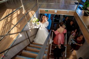 Overhead view of a wedding party descending wooden stairs in an elegant venue.