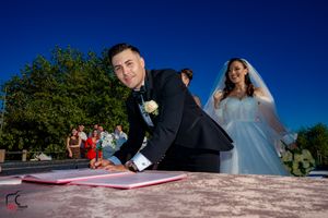 Creative angle of marriage certificate signing during outdoor mountain wedding ceremony.