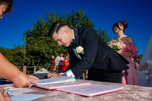 Low angle view of wedding ceremony document signing with guests in background.