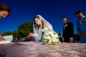 Artistic perspective of marriage certificate signing with bouquet and blue sky.