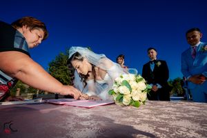 Creative angle of wedding document signing with white flowers and guests.