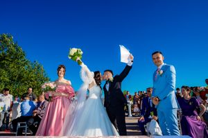 Wedding party members in blue and white attire gather for document signing ceremony.