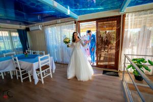 Wedding venue interior with elegant white decor and natural lighting streaming through windows.