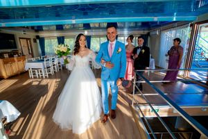 Elegant wedding reception space with blue ceiling lighting and white decorative elements.