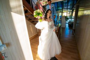 Sunlit indoor wedding venue with wooden floors and white drapery creating an elegant atmosphere.