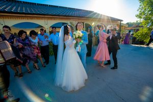 Wedding celebration panorama showing guests dancing under a covered outdoor venue.