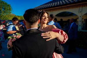 A couple dances together at an outdoor celebration under bright blue skies.