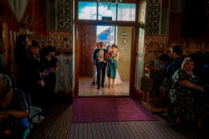 A wedding ceremony entrance in an orthodox church with decorative walls and red carpet.