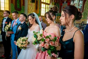 Orthodox wedding ceremony in an ornate church with traditional green and gold vestments and pink bridesmaids dresses.