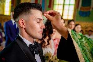 Solemn moment during Orthodox wedding ritual with priest in traditional green vestments.