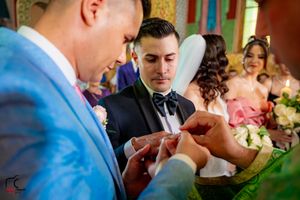 Wedding ceremony in progress inside beautifully decorated Orthodox church with traditional elements.