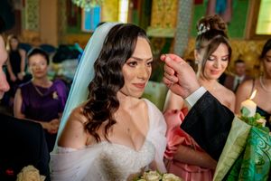 Wedding celebration in a grand hall with ornate chandeliers and decorative elements.