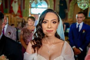 Bride wearing a white veil and elegant dress during an indoor wedding ceremony.