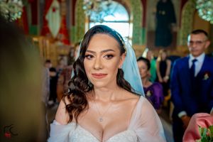 Traditional wedding ceremony in progress inside a church with arched windows and floral decorations.