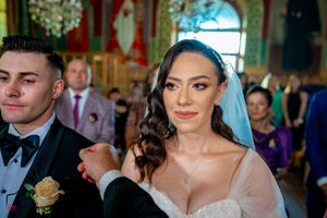 Wedding ceremony participants gathered in an ornately decorated venue with chandelier lighting.