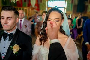 Formal wedding ceremony in progress with guests seated in an elegantly decorated hall.