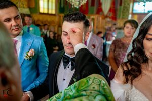 Wedding guests and wedding party assembled in a decorated venue with ambient lighting.