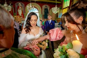 Ornate church interior with green and gold decor features stained glass windows and crystal chandeliers during a ceremony.