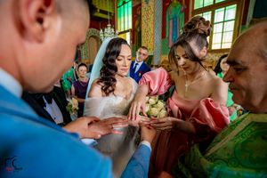 Wedding guests gather in an ornately decorated Orthodox church with golden walls and green trim.