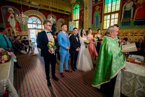 Traditional Orthodox church ceremony with priests in green vestments and ornate golden decorations.