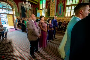 Wedding celebration in an Orthodox church featuring traditional architecture and ceremonial elements.