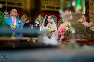 Artistic wedding photo framed through foreground decorations in a grand historic ballroom.